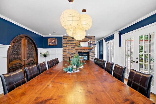 1444 Guildford Dr, Bourbonnais, IL 60914 - dining room with french doors, a decorative wall, crown molding, a wainscoted wall, and a fireplace