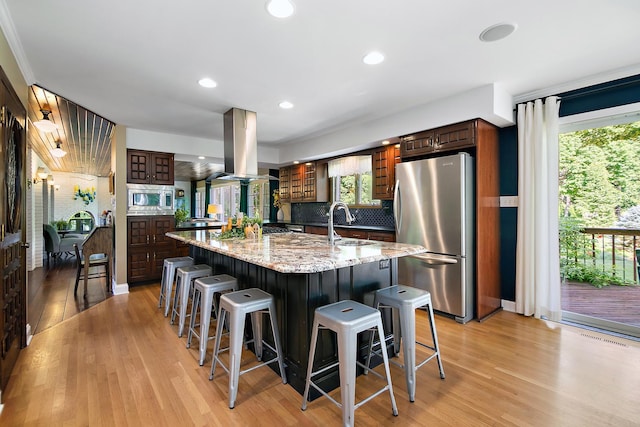 1444 Guildford Dr, Bourbonnais, IL 60914 - kitchen with stainless steel appliances, island exhaust hood, tasteful backsplash, light wood-type flooring, and a breakfast bar