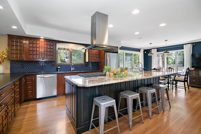 1444 Guildford Dr, Bourbonnais, IL 60914 - kitchen with stainless steel appliances, island exhaust hood, a kitchen bar, decorative backsplash, and light wood-style floors