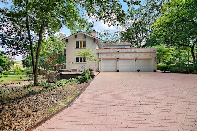1444 Guildford Dr, Bourbonnais, IL 60914 - view of front of home featuring decorative driveway, an attached garage, and a chimney