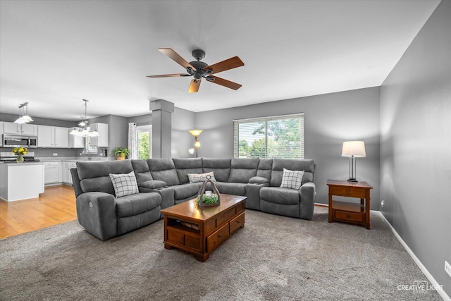 1918 Congrove Dr, Aurora, IL 60504 - living room with light colored carpet, ceiling fan, a chandelier, and decorative columns
