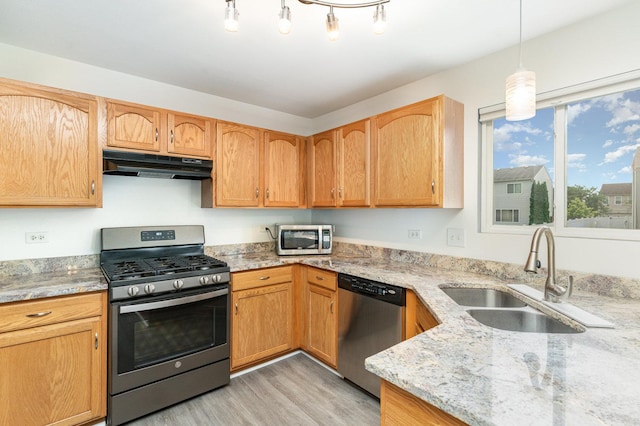 1704 Cascade Ridge Dr, Plainfield, IL 60586 - kitchen with stainless steel appliances, under cabinet range hood, light wood-style flooring, light stone counters, and decorative light fixtures