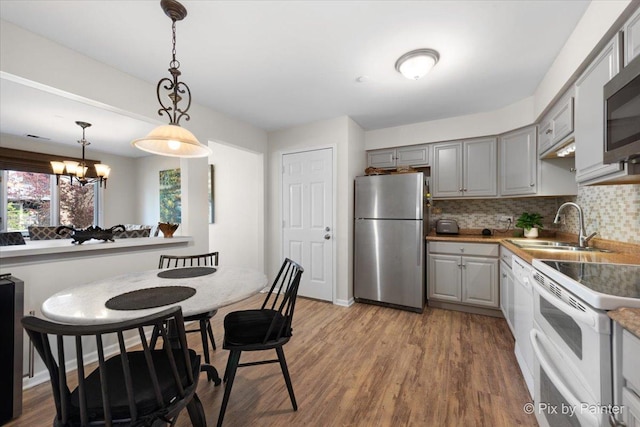 2109 Ammer Ridge Ct Unit 201, Glenview, IL 60025 - kitchen with stainless steel appliances, gray cabinetry, tasteful backsplash, a chandelier, and wood finished floors