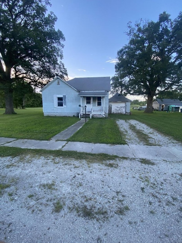 106 W Sheridan St, Watseka, IL 60970 - bungalow with a front yard, gravel driveway, and a garage