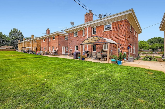 437 S Elmhurst Rd, Mount Prospect, IL 60056 - back of house with a chimney, brick siding, a lawn, and a patio