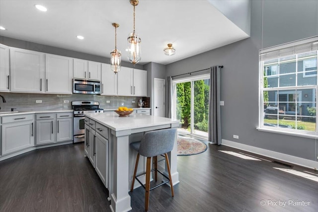 561 S Jade Ln Unit 1106, Round Lake, IL 60073 - kitchen featuring appliances with stainless steel finishes, light countertops, dark wood-type flooring, decorative backsplash, and recessed lighting