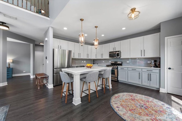 561 S Jade Ln Unit 1106, Round Lake, IL 60073 - kitchen featuring appliances with stainless steel finishes, light countertops, a kitchen breakfast bar, decorative backsplash, and a center island