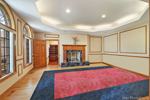 74 Dundee Ln, Barrington Hills, IL 60010 - living room with a tray ceiling, a premium fireplace, light wood-type flooring, healthy amount of natural light, and recessed lighting