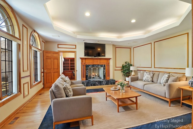 74 Dundee Ln, Barrington Hills, IL 60010 - living room with a raised ceiling, light wood-style flooring, a fireplace, healthy amount of natural light, and recessed lighting