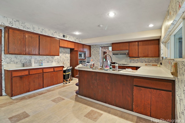 74 Dundee Ln, Barrington Hills, IL 60010 - kitchen featuring wallpapered walls, under cabinet range hood, stainless steel microwave, light countertops, and a peninsula