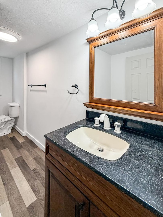 821 W Douglas St, Freeport, IL 61032 - bathroom with wood finished floors, vanity, and a textured ceiling