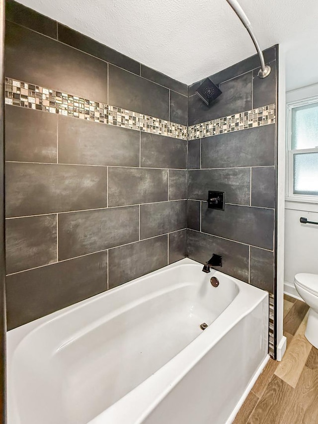 821 W Douglas St, Freeport, IL 61032 - bathroom featuring wood finished floors, bathtub / shower combination, and a textured ceiling