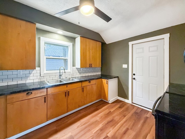821 W Douglas St, Freeport, IL 61032 - kitchen with black range with electric stovetop, ceiling fan, backsplash, light wood-style floors, and dark countertops