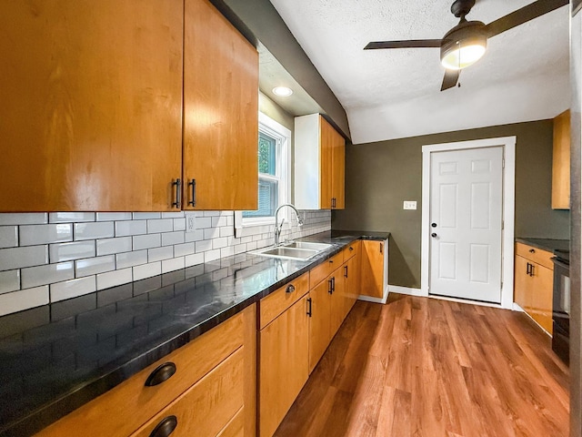 821 W Douglas St, Freeport, IL 61032 - kitchen with wood finished floors, decorative backsplash, vaulted ceiling, ceiling fan, and a textured ceiling