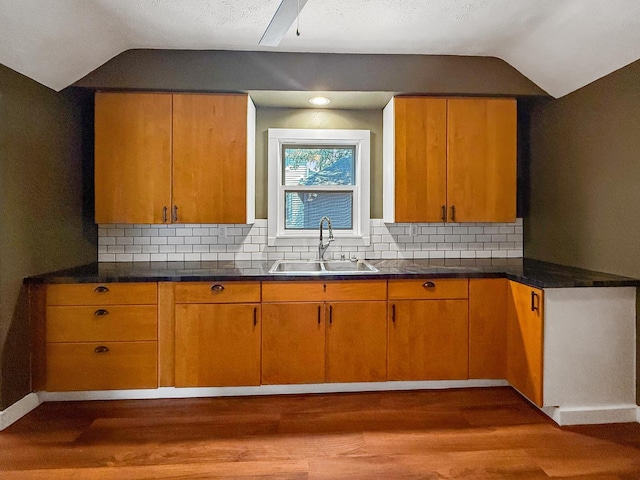 821 W Douglas St, Freeport, IL 61032 - kitchen with lofted ceiling, wood finished floors, backsplash, and dark countertops