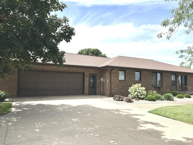 70 N Main St, Lamoille, IL 61330 - ranch-style house with an attached garage, brick siding, driveway, and a shingled roof