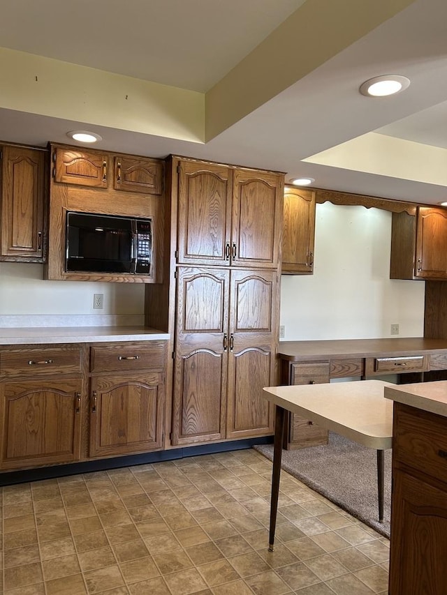 70 N Main St, Lamoille, IL 61330 - kitchen with black microwave, light countertops, recessed lighting, a tray ceiling, and brown cabinets