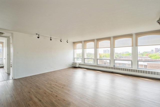 1450 E 55th Pl Unit 630S, Chicago, IL 60637 - empty room featuring rail lighting, wood finished floors, and a baseboard radiator