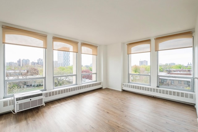 1450 E 55th Pl Unit 630S, Chicago, IL 60637 - unfurnished sunroom with a city view, radiator, wood finished floors, and a baseboard heating unit