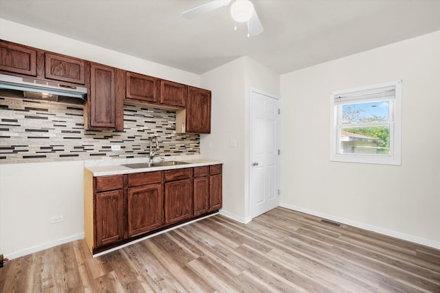 2133 Luther Ave, Lockport, IL 60441 - kitchen featuring light wood-style flooring, decorative backsplash, a ceiling fan, light countertops, and under cabinet range hood