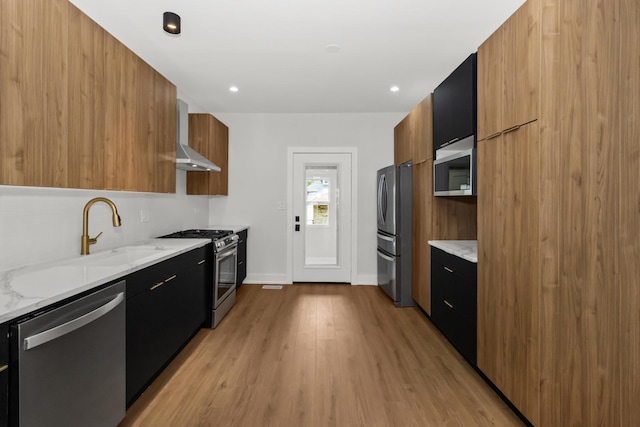 8114 S Paxton Ave, Chicago, IL 60617 - kitchen with appliances with stainless steel finishes, modern cabinets, wall chimney range hood, light wood-style flooring, and dark cabinets