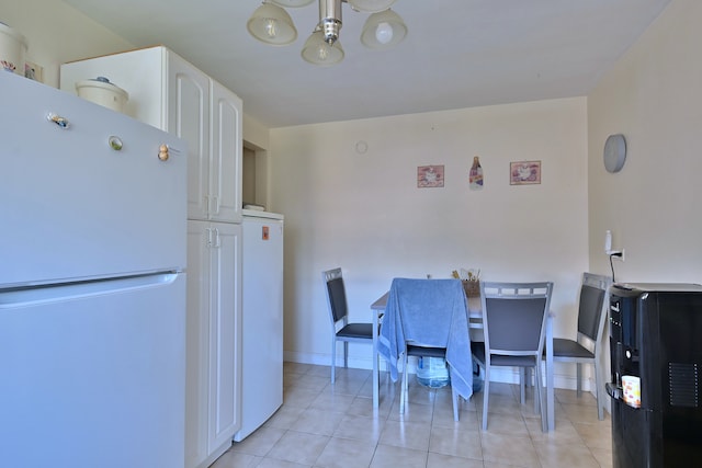 dining area with a chandelier and light tile patterned floors
