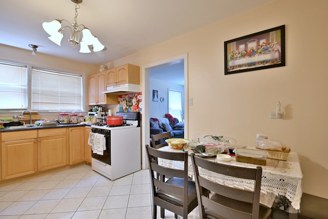 kitchen featuring white range with gas stovetop, light brown cabinets, a chandelier, under cabinet range hood, and light tile patterned floors