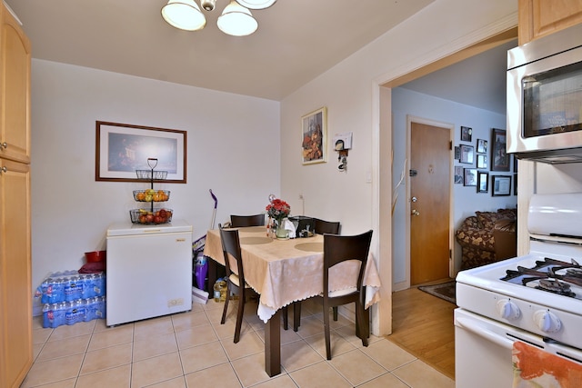 dining room with light tile patterned floors and a chandelier