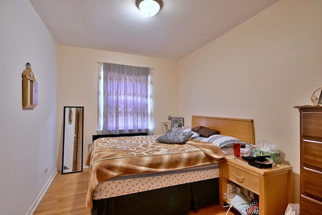 bedroom featuring wood finished floors and baseboards