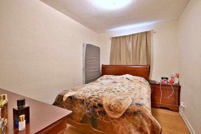 bedroom with light wood-style floors and baseboards
