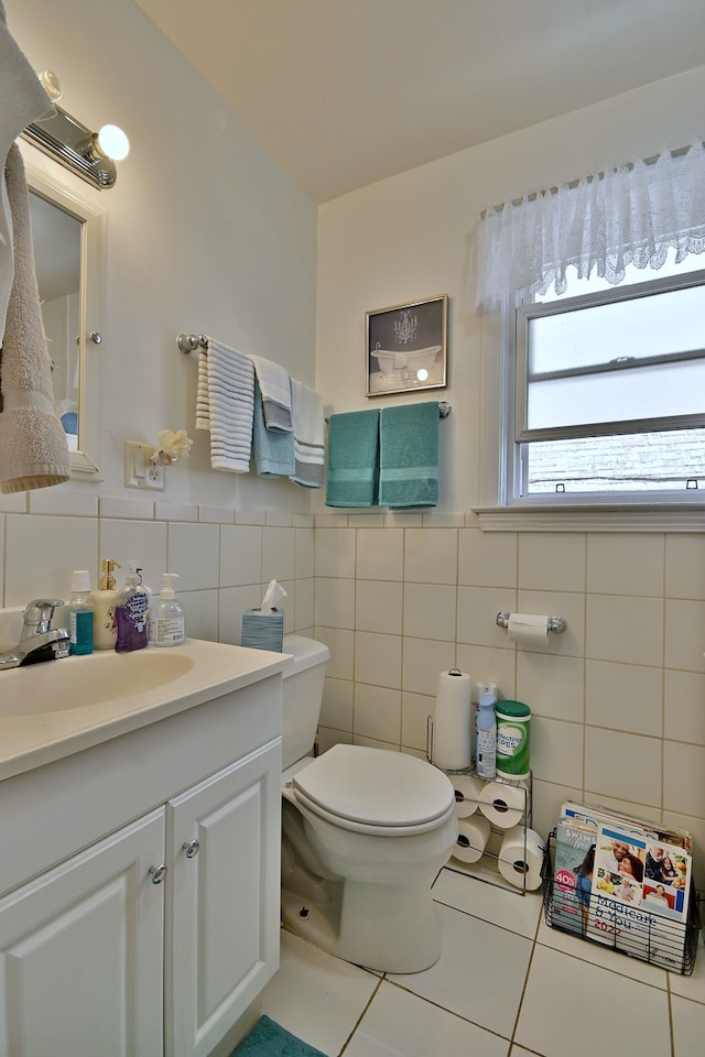 bathroom featuring tile walls, tile patterned floors, vanity, and a wainscoted wall