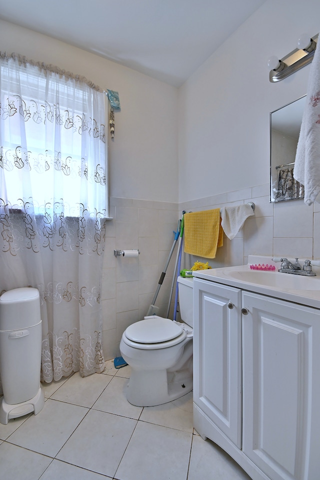 full bath featuring tile walls, vanity, tile patterned flooring, and wainscoting