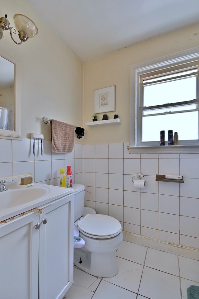 bathroom featuring tile walls, tile patterned flooring, vanity, and a wainscoted wall