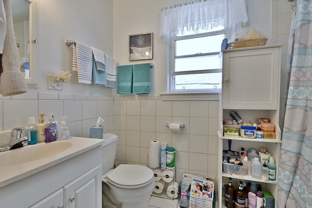 full bathroom featuring vanity and tile walls