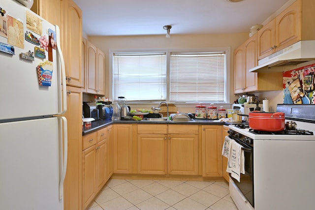 kitchen featuring white appliances, under cabinet range hood, dark countertops, and plenty of natural light