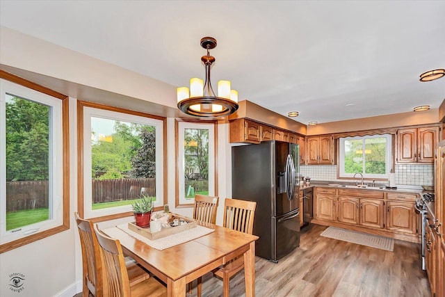 18905 Meadowview Dr, Mokena, IL 60448 - kitchen with stainless steel appliances, tasteful backsplash, a chandelier, light wood-style floors, and decorative light fixtures