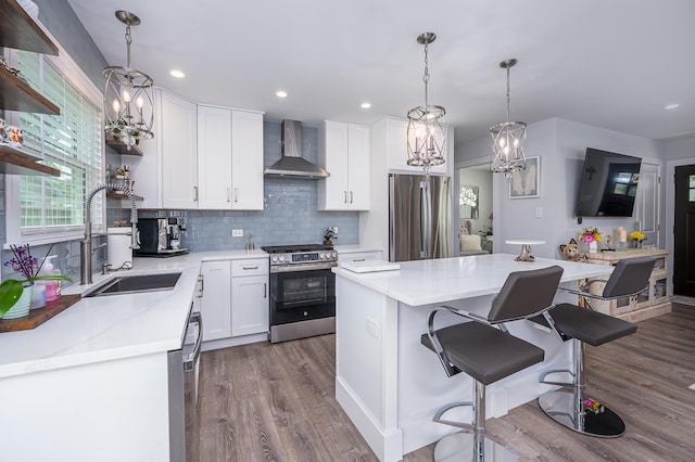 1815 Evergreen Ave, Hanover Park, IL 60133 - kitchen with appliances with stainless steel finishes, wall chimney range hood, dark wood-type flooring, white cabinets, and a center island