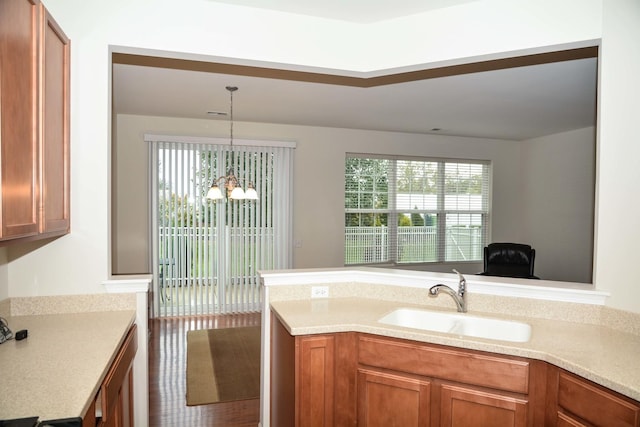 13445 Meadowlark Ln, Huntley, IL 60142 - kitchen featuring a chandelier, light countertops, brown cabinetry, and healthy amount of natural light