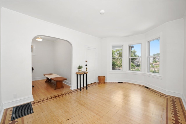 1629 W Foster Ave, Chicago, IL 60640 - empty room featuring arched walkways and wood finished floors