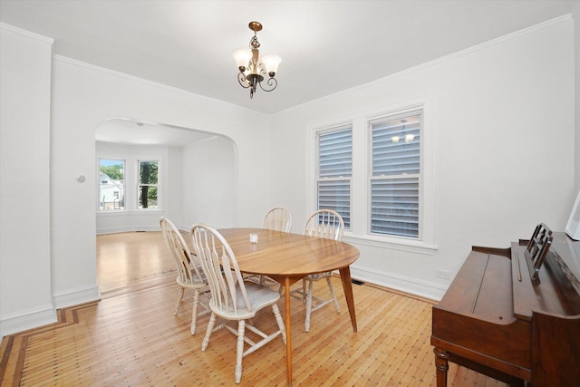 1629 W Foster Ave, Chicago, IL 60640 - dining area featuring arched walkways, a chandelier, light wood-type flooring, and crown molding