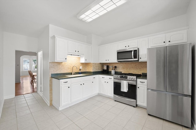 1629 W Foster Ave, Chicago, IL 60640 - kitchen with appliances with stainless steel finishes, dark countertops, decorative backsplash, and light tile patterned floors