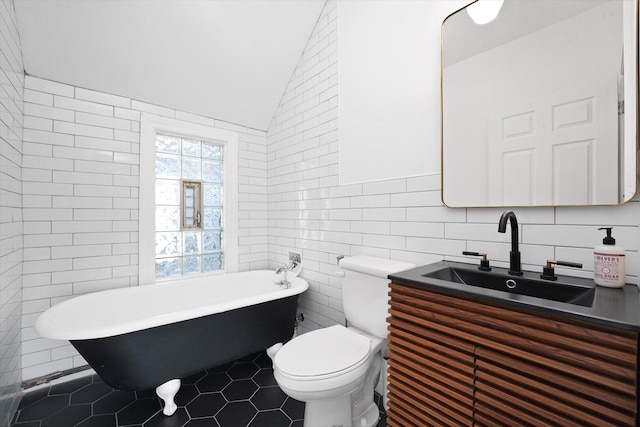 1629 W Foster Ave, Chicago, IL 60640 - full bath featuring tile walls, a freestanding tub, tile patterned flooring, vaulted ceiling, and vanity