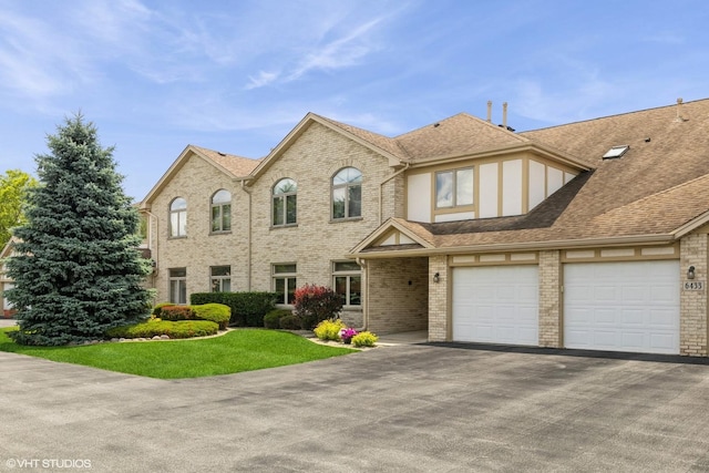 6433 Pine Cone Dr Unit 1, Tinley Park, IL 60477 - view of front of property featuring driveway, brick siding, a shingled roof, a front lawn, and a garage