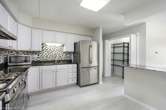 6211 Lincoln Ave Unit 402, Morton Grove, IL 60053 - kitchen with appliances with stainless steel finishes, wall chimney exhaust hood, a textured ceiling, backsplash, and light wood finished floors