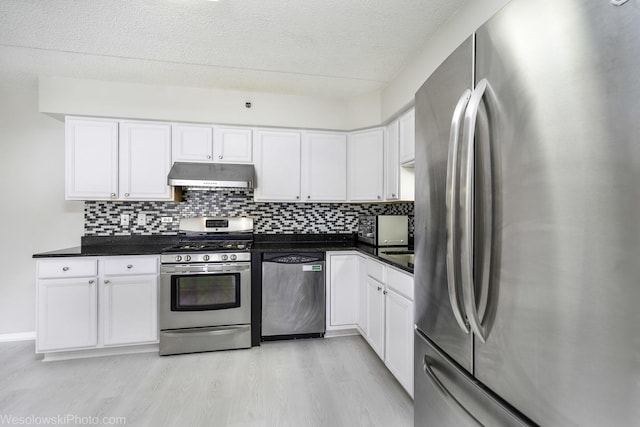 6211 Lincoln Ave Unit 402, Morton Grove, IL 60053 - kitchen featuring stainless steel appliances, under cabinet range hood, light wood finished floors, dark countertops, and a textured ceiling