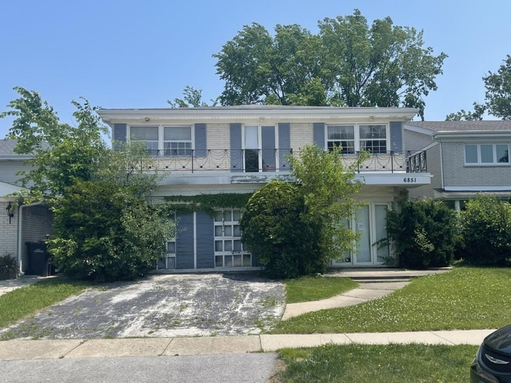 6851 N Lockwood Ave, Skokie, IL 60077 - view of front of property with a balcony, driveway, and brick siding