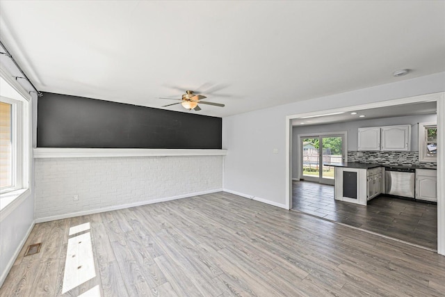 410 N 4th St, Saint Joseph, IL 61873 - unfurnished living room with ceiling fan, dark wood finished floors, and brick wall