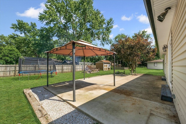 410 N 4th St, Saint Joseph, IL 61873 - fenced backyard featuring a trampoline, a storage unit, a patio area, a detached carport, and a gazebo