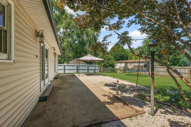 410 N 4th St, Saint Joseph, IL 61873 - fenced backyard featuring a trampoline and a patio