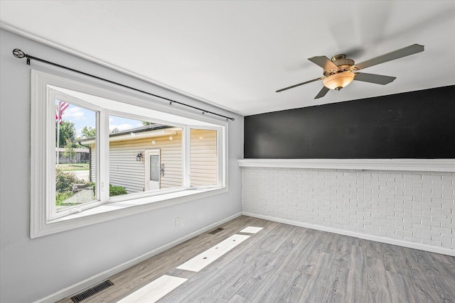 410 N 4th St, Saint Joseph, IL 61873 - unfurnished room featuring brick wall, wood finished floors, and a ceiling fan